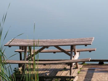 Wooden bench on pier over lake