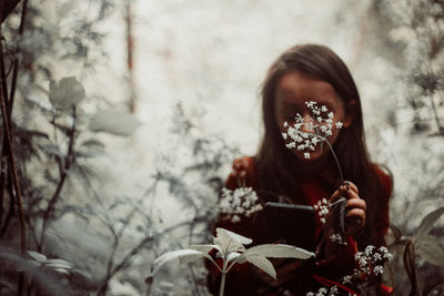 High angle view of woman standing by flowering plants during winter
