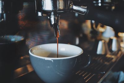 Close-up of coffee pouring in cup