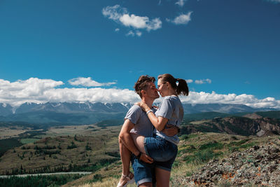 Full length of friends standing on mountain against sky