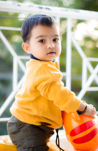 Cute boy looking away while standing outdoors