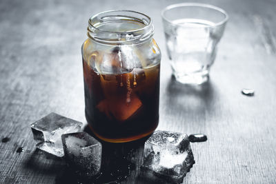 Close-up of drink in glass jar with ice on table