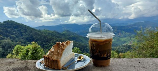 Close-up of coffee on table against mountains