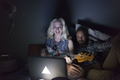 Young couple looking at a laptop in bed