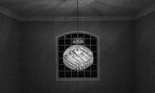 Low angle view of illuminated chandelier hanging on ceiling