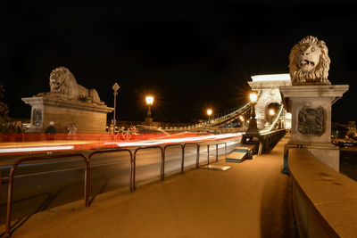 Statue of illuminated bridge at night