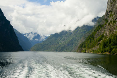 Scenic view of river and mountains against sky