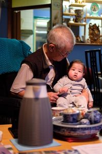 Full length of friends sitting at home