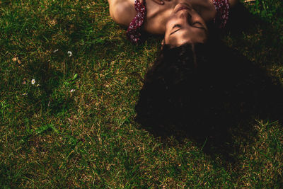 Young woman lying on grass with long straight hair