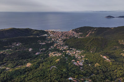 High angle view of townscape by sea against mountain