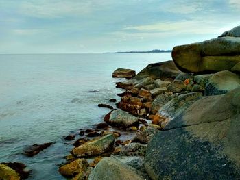 Rocks on beach against sky