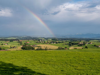 Scenic view of rainbow over field against sky