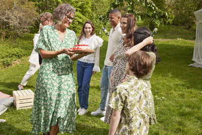 Family celebrating with cake outdoors