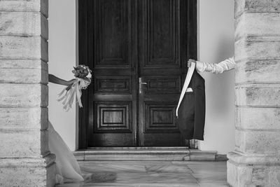 Cropped image of bride and bridegroom at corridor