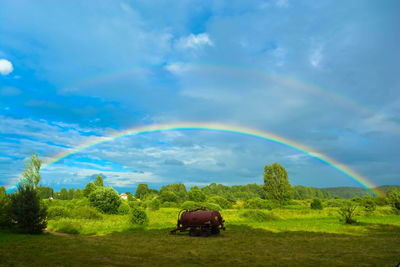 Scenic view of rainbow over field against sky