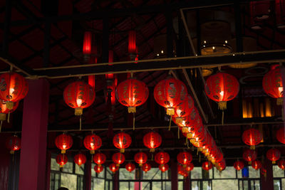 Low angle view of illuminated lanterns hanging at night