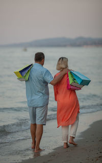 Rear view of couple standing on beach