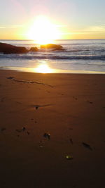 Scenic view of beach against sky during sunset