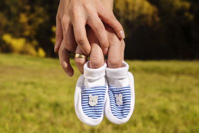 Cropped hands holding baby booties