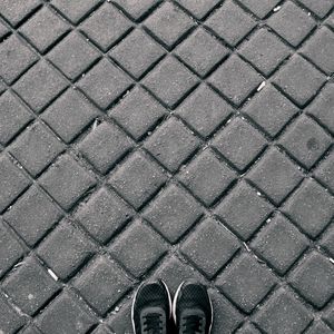 Low section of man standing on cobblestone