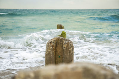 Close-up of wave on beach against sky