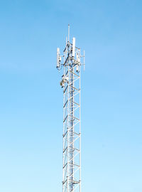 Low angle view of communications tower against clear blue sky