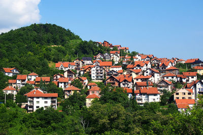 Houses in town against clear blue sky