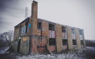 Abandoned building against clear sky during winter