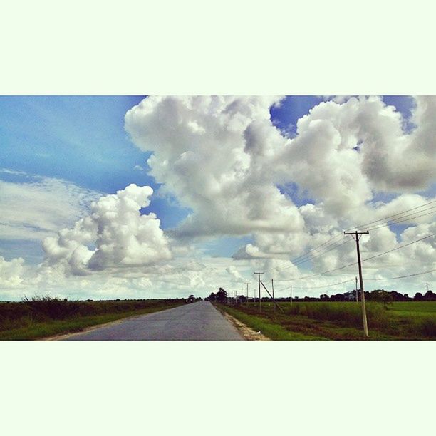 transfer print, sky, cloud - sky, auto post production filter, the way forward, cloudy, diminishing perspective, cloud, field, road, vanishing point, transportation, landscape, blue, grass, day, nature, green color, rural scene, outdoors