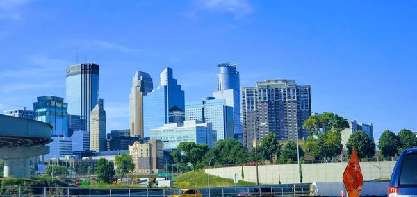 Modern buildings in city against blue sky