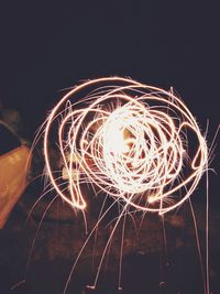 Low angle view of light trails against sky at night