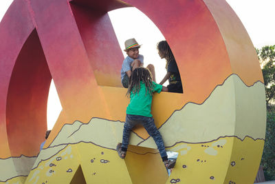 Low angle view of friends playing at playground