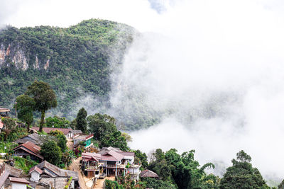 Scenic view of waterfall and buildings against sky