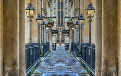 Empty walkway amidst illuminated gas lights at historic building