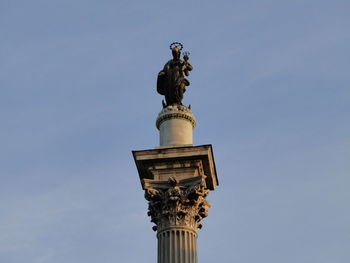 Low angle view of statue on monument against sky