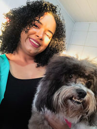 Portrait of smiling woman with dog at home