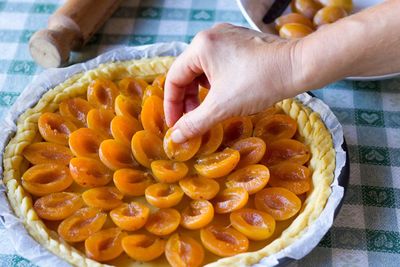 Close-up of person preparing fruit tarte 