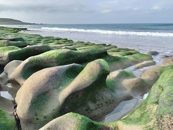 Rocks on beach against sky