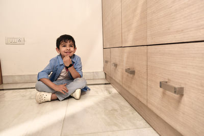 Portrait of boy sitting on floor