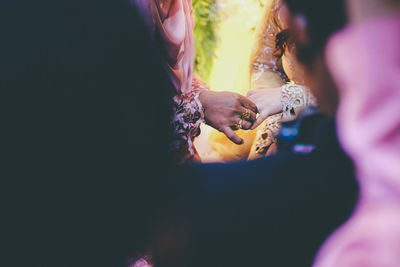 Midsection of couple exchanging wedding rings