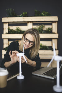 Young woman using phone while sitting on table