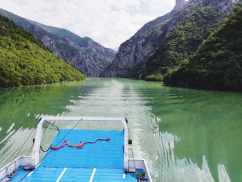 Scenic view of lake by mountains against sky