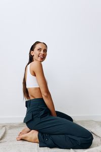 Portrait of young woman standing against white background