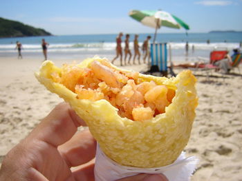 Close-up of hand holding ice cream at beach