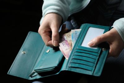 Midsection of woman removing money from purse