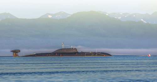 Lighthouse by sea against mountain