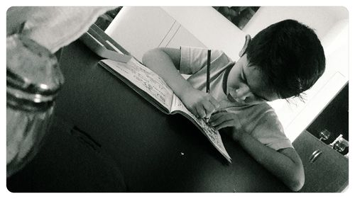 High angle view of boy reading book