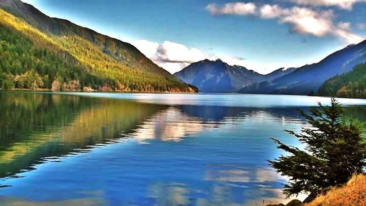 SCENIC VIEW OF CALM LAKE AGAINST MOUNTAIN RANGE