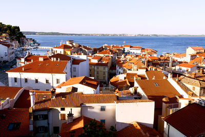 High angle view of townscape by sea against clear sky
