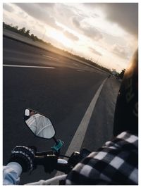 Low section of man on road against sky